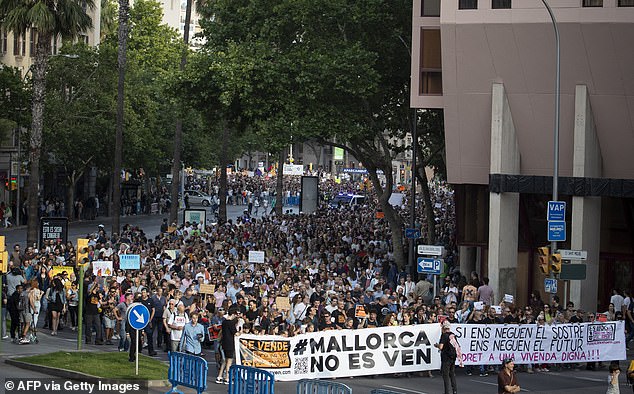 Protesters hold a banner that says 