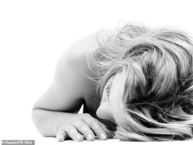 In a photo from 1994, Kylie Minogue is seen naked and lying on a white floor, turning her head to the side. She was part of The Kylie Bible.