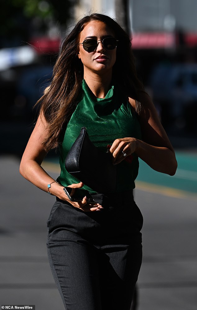 The socialite wore a modest green satin halter-neck top, black suit pants, black patent leather shoes and a black leather handbag.