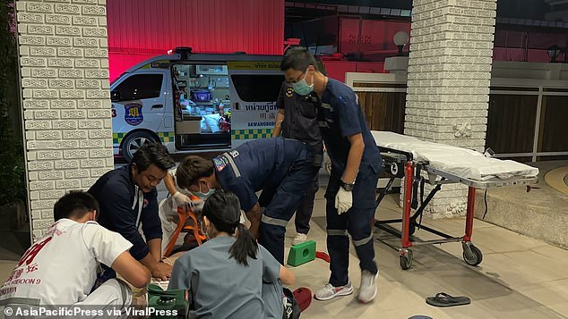 Paramedics try to revive the Russian man who hit his head on the tiled floor in the early hours of May 27.