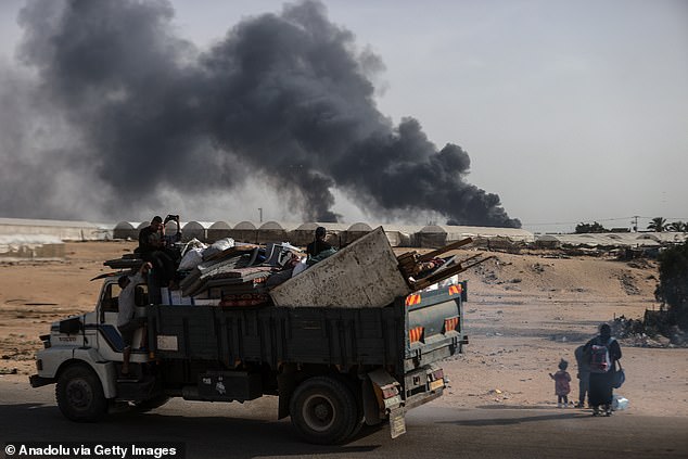 Palestinians, carrying their personal belongings, migrate to areas they consider safe after the Israeli army attacked tents in Al-Mawasi.