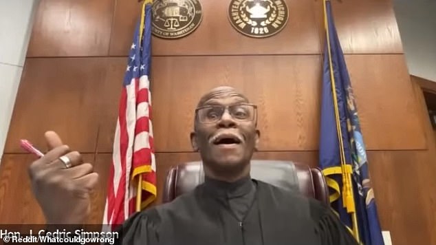 District Judge Cedric Simpson of Ann Arbor is seen on the video reacting in disbelief as Harris dials in, with his seat belt visible over his torso and his car obviously moving.