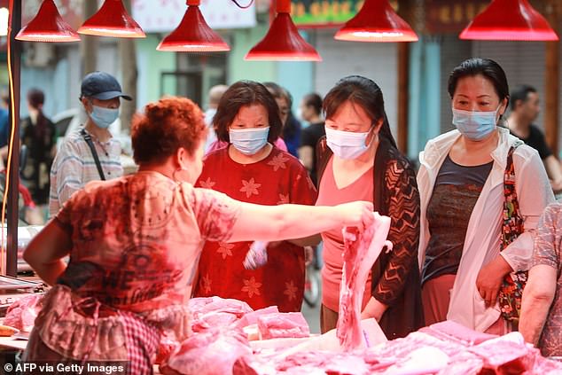 Customers buy meat at a market in Shenyang, northeast China's Liaoning province.