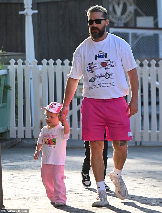 Shia was dressed casually in a set of eye-catching hot pink shorts and a white T-shirt with an Indianapolis 500 print.