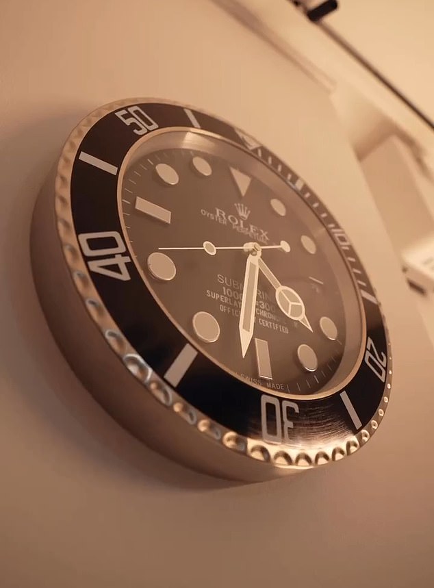 A Rolex watch, pictured, can also be seen in the video, along with luxurious aroma diffusers and a flat-screen TV.