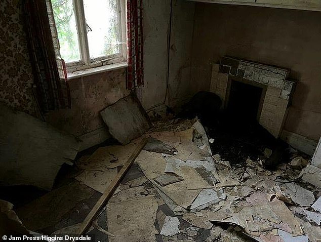 Inside one of the rooms of the property that has a ruined fireplace.