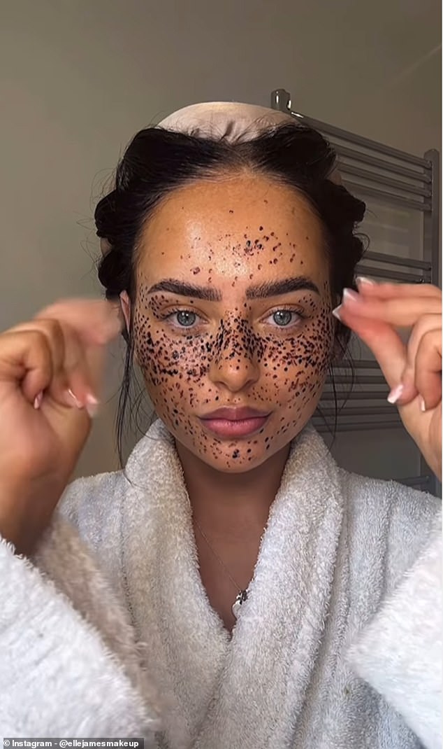 Elle takes out a tube of dark brown henna and begins drawing groups of dots on the bridge of her nose, cheeks, eyelids, forehead, and chin.