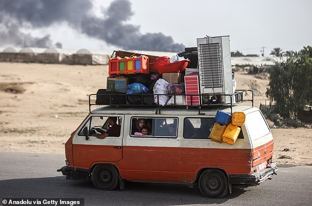 Palestinians, carrying their personal belongings, migrate to areas they consider safe after the Israeli army attacked tents in Al-Mawasi, previously declared 