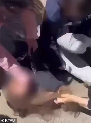 The student in gray pants is seen being beaten by others.