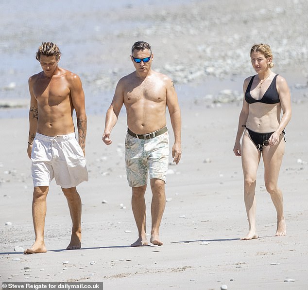 She posed up a storm at Playa Hermosa, where she was photographed frolicking with Armando (left) and a friend on Friday.