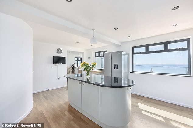 The kitchen island on the top floor with a large picture window overlooking the Cornish coast.