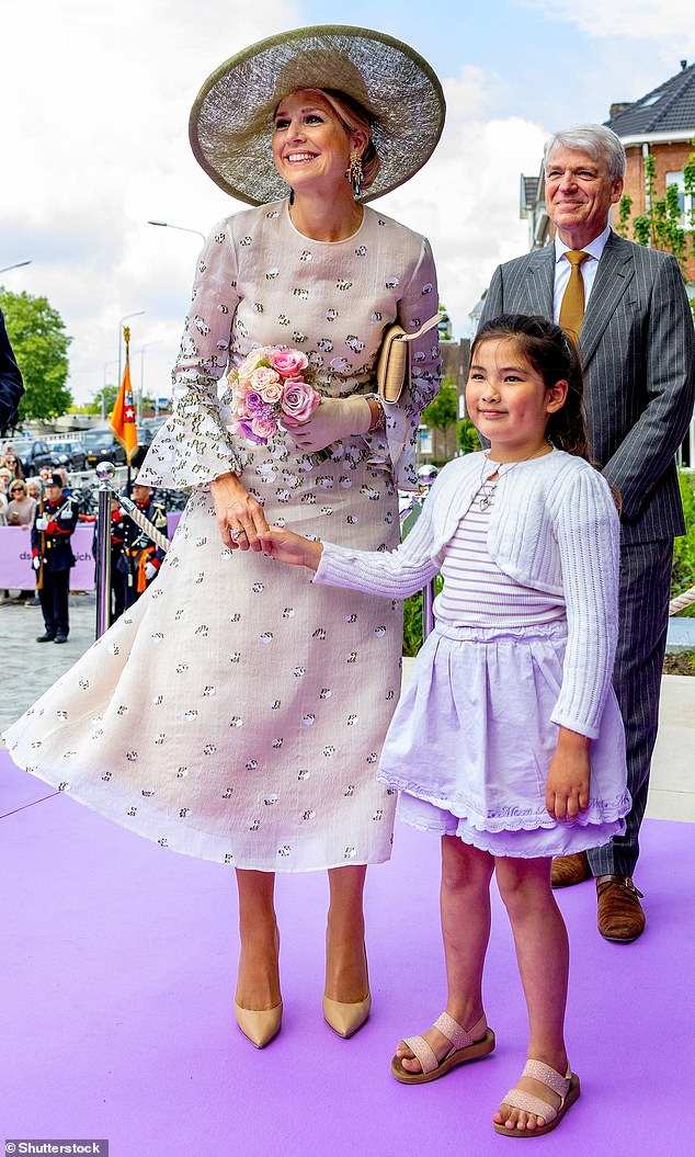 The royal looked delighted as she accepted a small bouquet of flowers from a young girl upon her arrival.