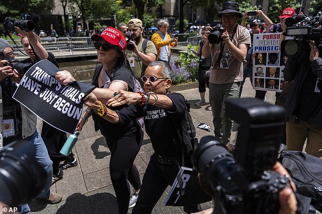 A woman ripped signs from a protester's hands as nervous supporters on both sides showed their frustration at the historic verdict.