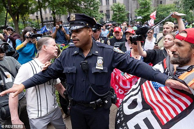 A New York police officer was seen separating Trump supporters from protesters outside the courthouse when the two groups clashed Thursday morning.