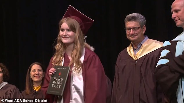 Wearing a maroon cap and gown, Jenkins walked across the stage shaking hands with everyone in front of Bub and then pulled out a copy of the book as she approached him.