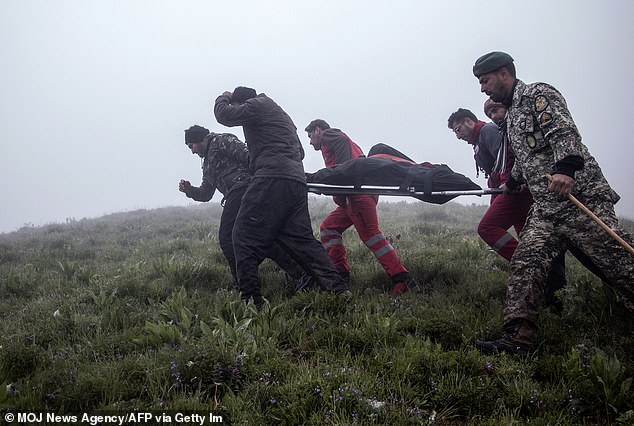 Rescuers recover bodies at the crash site of a helicopter carrying Iran's president, his foreign minister and others in a fog-covered mountainous area of ​​Varzaghan, northwest Iran, on May 20, 2024.