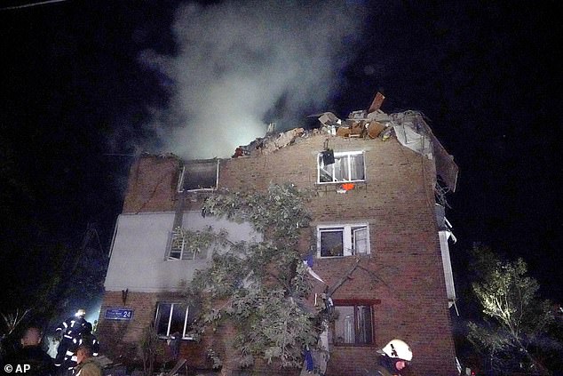 Firefighters put out a fire at an apartment building damaged by the Russian missile attack in Kharkiv, Ukraine