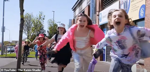 Pictured: Spark's music video. In the video, the children attended a rave-like stage and donned bucket hats, gold chains and colorful clothing while singing enthusiastically for the camera.