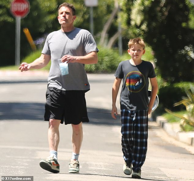 The preteen carried a Frisbee while he and his father chewed ice from a to-go cup.