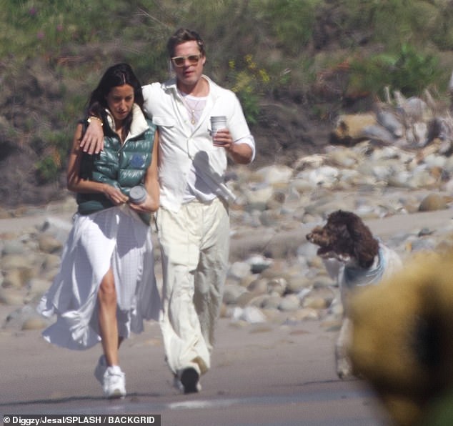 The couple seemed to be in great spirits as they chatted and watched their two dogs run along the shore alongside them.