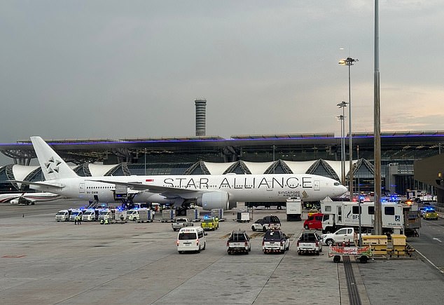 One passenger was killed and 30 others injured on a flight from London to Singapore this afternoon, forcing an emergency landing in Thailand. Pictured: The plane and ambulances are seen on the tarmac at Suvarnabhumi International Airport in Bangkok today.