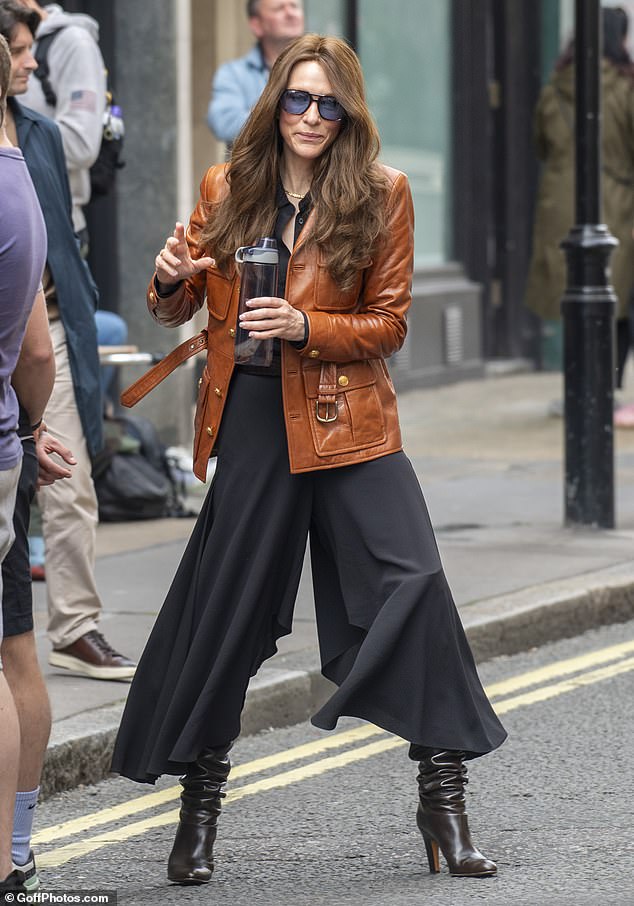 She looked incredible in a brown leather jacket over a wide-legged black jumpsuit, which she cinched at the waist with a matching belt.