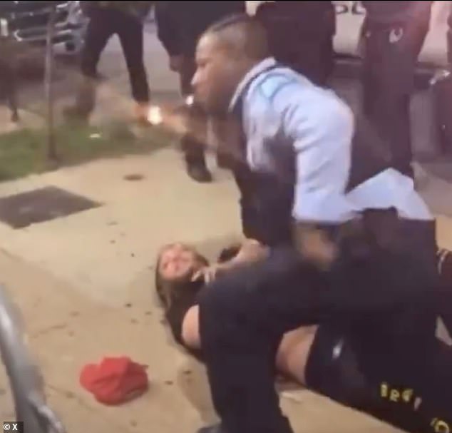 The officer is seen pinning a man to the ground while casually turning on