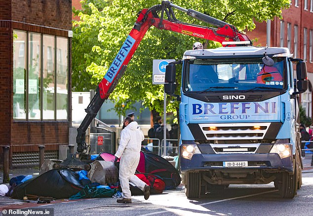 A truck-mounted crane was even deployed to tear the canvas structures from the pavement and deposit them in a container on May 1.