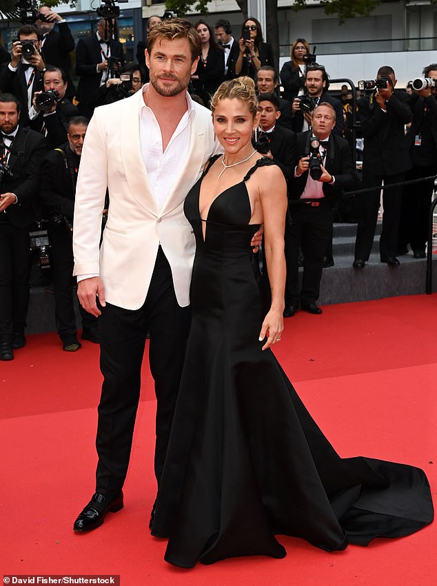 For the epic night, Elsa showed off her incredible figure in a low-cut black satin dress with elaborate jeweled straps and 1920s-style tassels as she posed arm in arm with Chris.