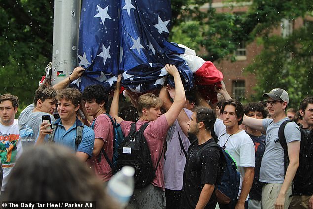 Students at the University of North Carolina are seen trying to keep hordes of pro-Palestinian protesters away from the American flag.