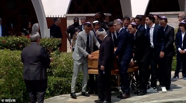 Ella's coffin is seen being carried by members of the temple.