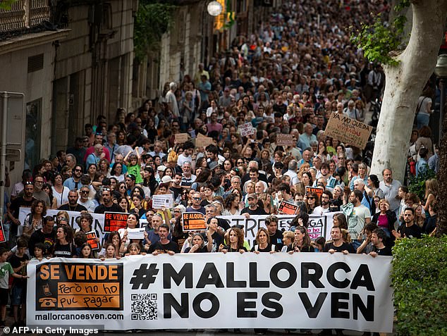 Protesters hold a banner that says 