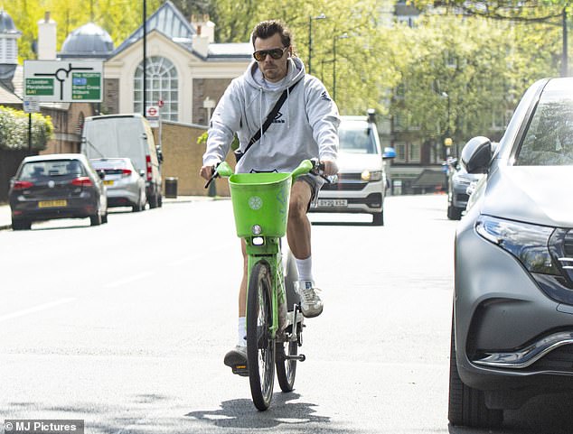 Harry Styles looked completely content as he rode around London's Primrose Hill on a rental electric bike on Saturday.