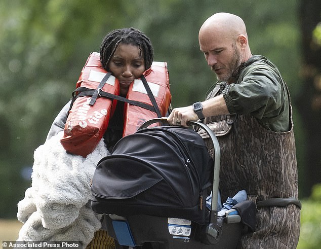 A woman welcomes her son after being evacuated by boat from their homes with the help of deputies from the Montgomery County Sheriff's Office on Friday.