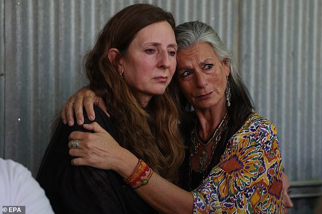 Shanni Louk's mother (left) is comforted by a friend during her daughter's funeral.