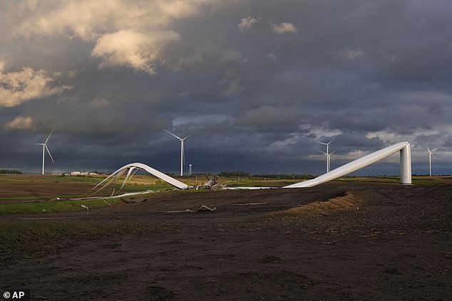 The remains of a wind turbine damaged by the tornado touch the ground in a field Tuesday near Prescott, Iowa.