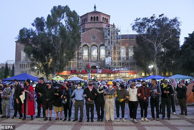 People link arms as they gather inside the pro-Palestinian protester camp on the UCLA campus.