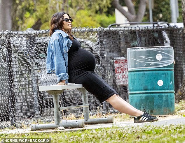 The mother-to-be wore a black dress that hid her growing baby bump, with a blue denim jacket over the dress.