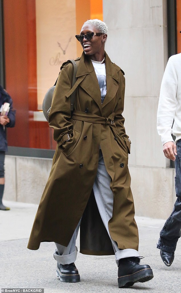 The 37-year-old, British-born and American-educated, donned a $3,150 Burberry 'Long Castleford' trench coat over a white T-shirt, light blue jeans and Dr. Martens '1460 Pascal Max' leather platform boots of $230.