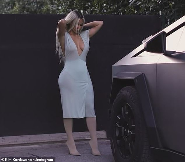 Kim Kardashian, 43, showed off her curves in a skin-tight faux wrap dress in a series of photos of her Cybertruck on social media on Sunday.