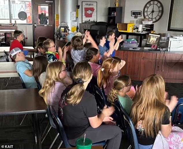 His classmates are seen celebrating alongside him as they watched the touching moment via livestream.