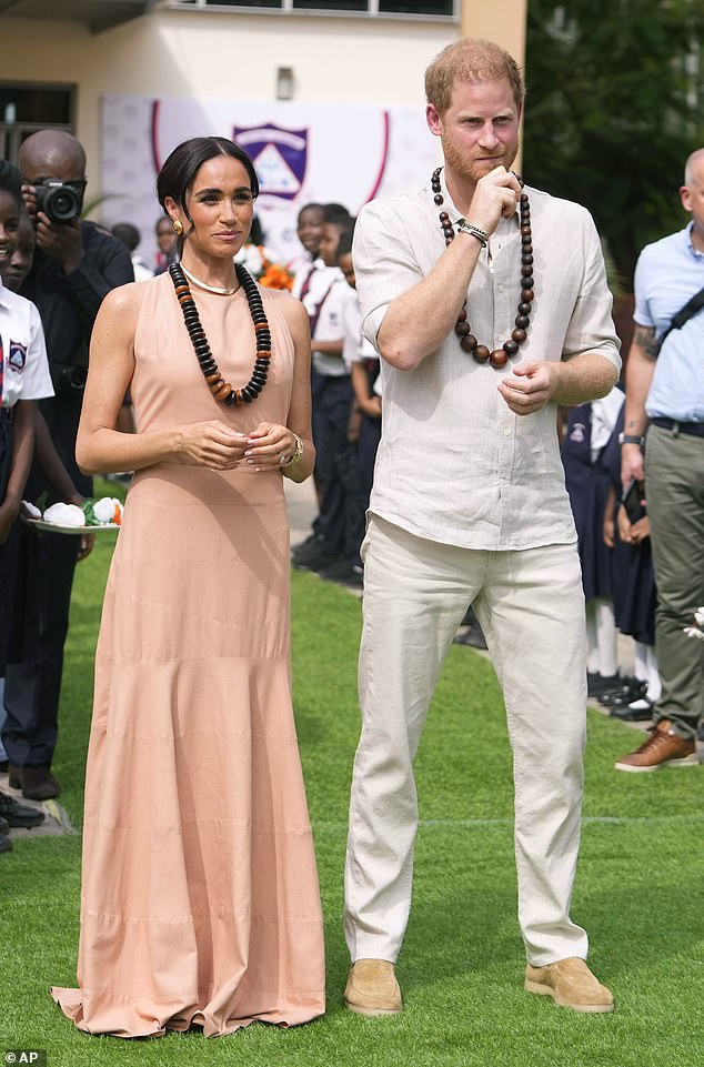 Meghan looked effortlessly chic as she bared her back in a peach sleeveless dress with a dropped hem, billowing skirt and cinched waist.