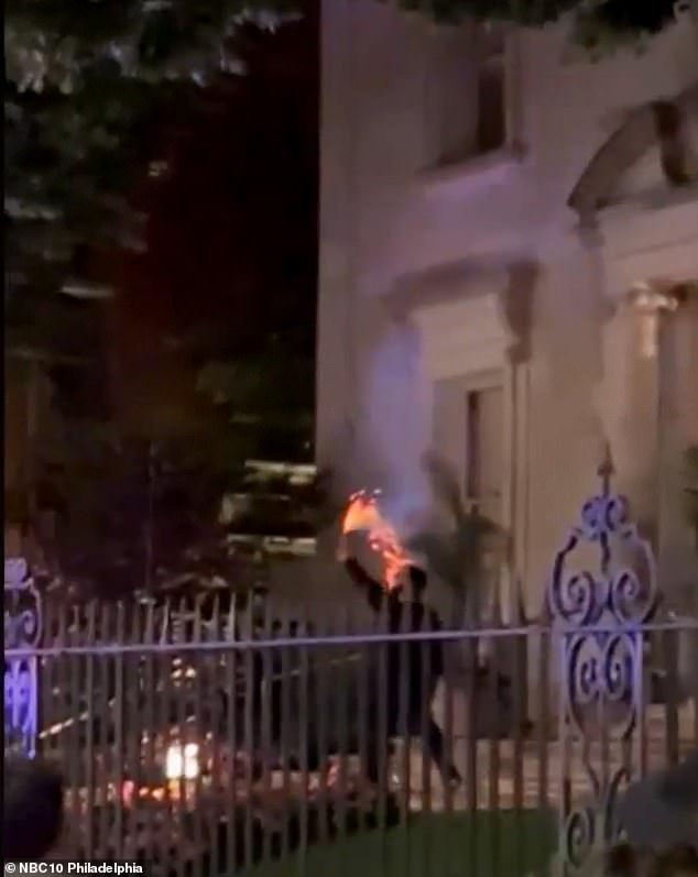 One person could be seen lighting a flare while another continued holding a Palestinian flag before knocking on the door of the house.