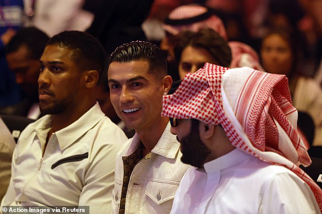 Ronaldo was situated in the front row for the fight, sitting next to Anthony Joshua (left)