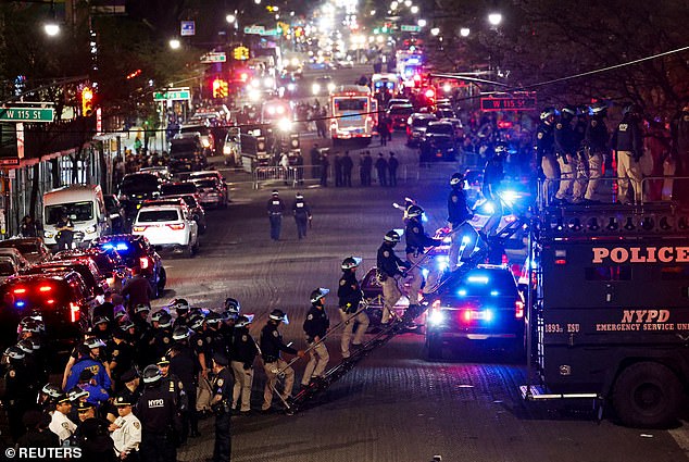 Police use a vehicle called 'The Bear' to enter Hamilton Hall from a public street, which was occupied by protesters, as other officers enter the Columbia University campus.