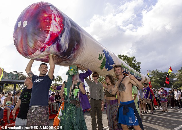 A group of revelers were photographed holding a large joint.