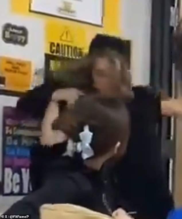 In the disturbing images you can see the teacher desperately trying to get between the two students. Suddenly, one of the children aggressively grabs the teacher and throws her to the ground while her classmates scream in shock.