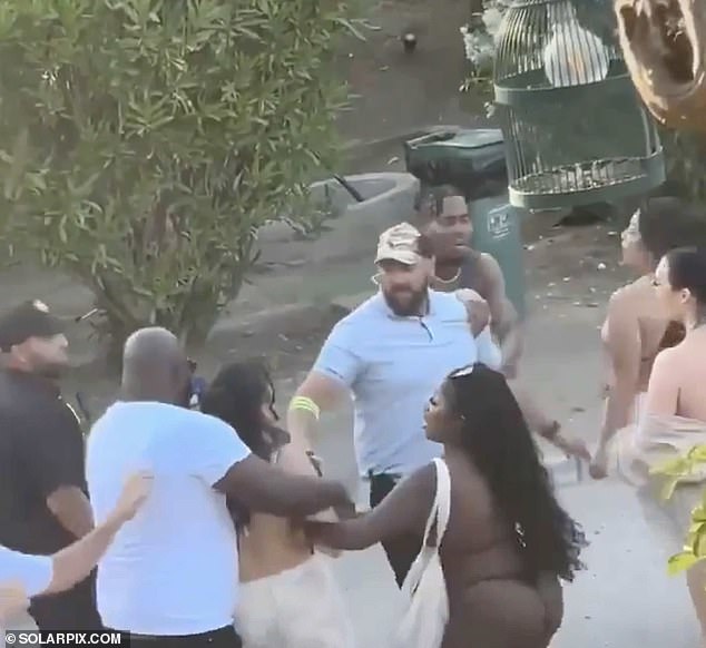 Security guards try to separate revelers fighting in the club parking lot.