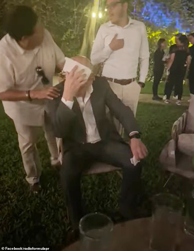 A man covers his head with a napkin after becoming sick Saturday at a wedding in Mexico from contaminated food.