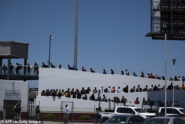 Asylum seekers walk to their interview appointment with US authorities at the El Chaparral border port in Tijuana, Baja California state, Mexico, on May 18.